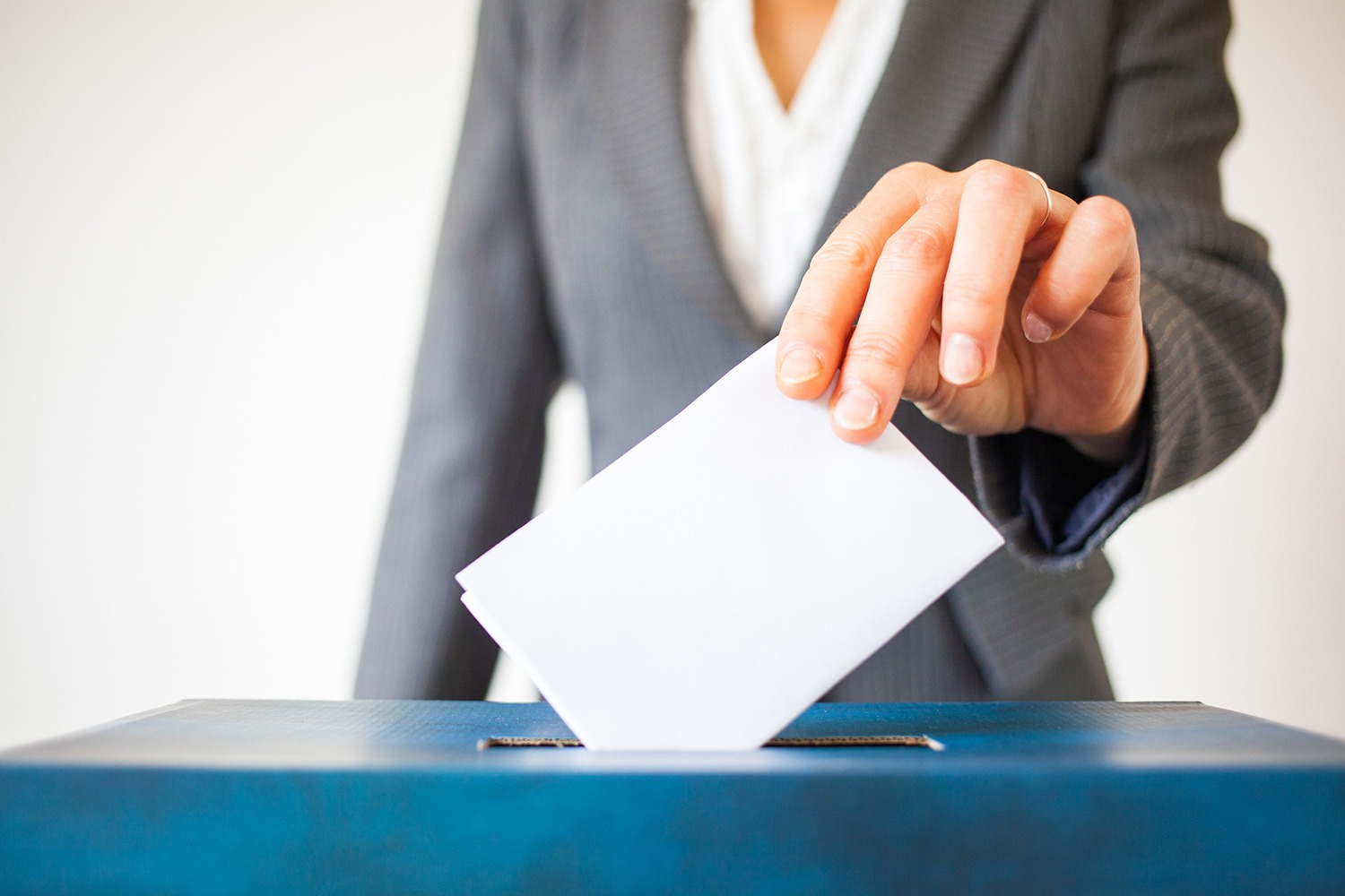 Personne glissant un bulletin de vote dans une urne