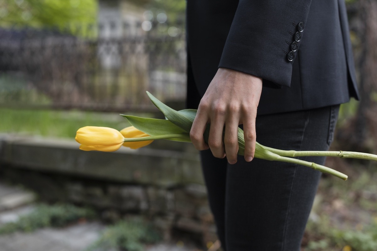 Personne tenant des tulipes jaunes en signe de deuil