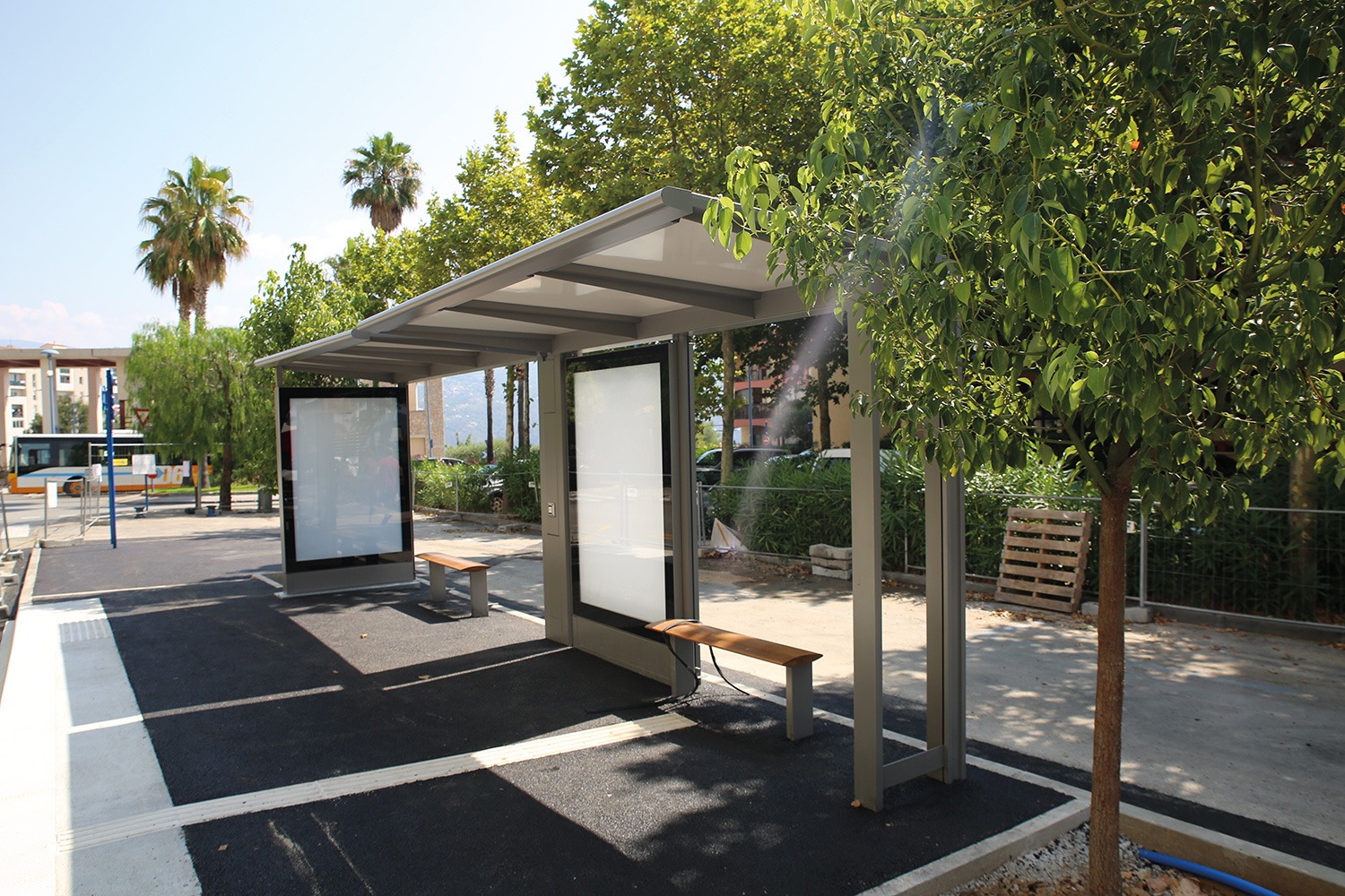 Abribus moderne avec banc et bus à Carros